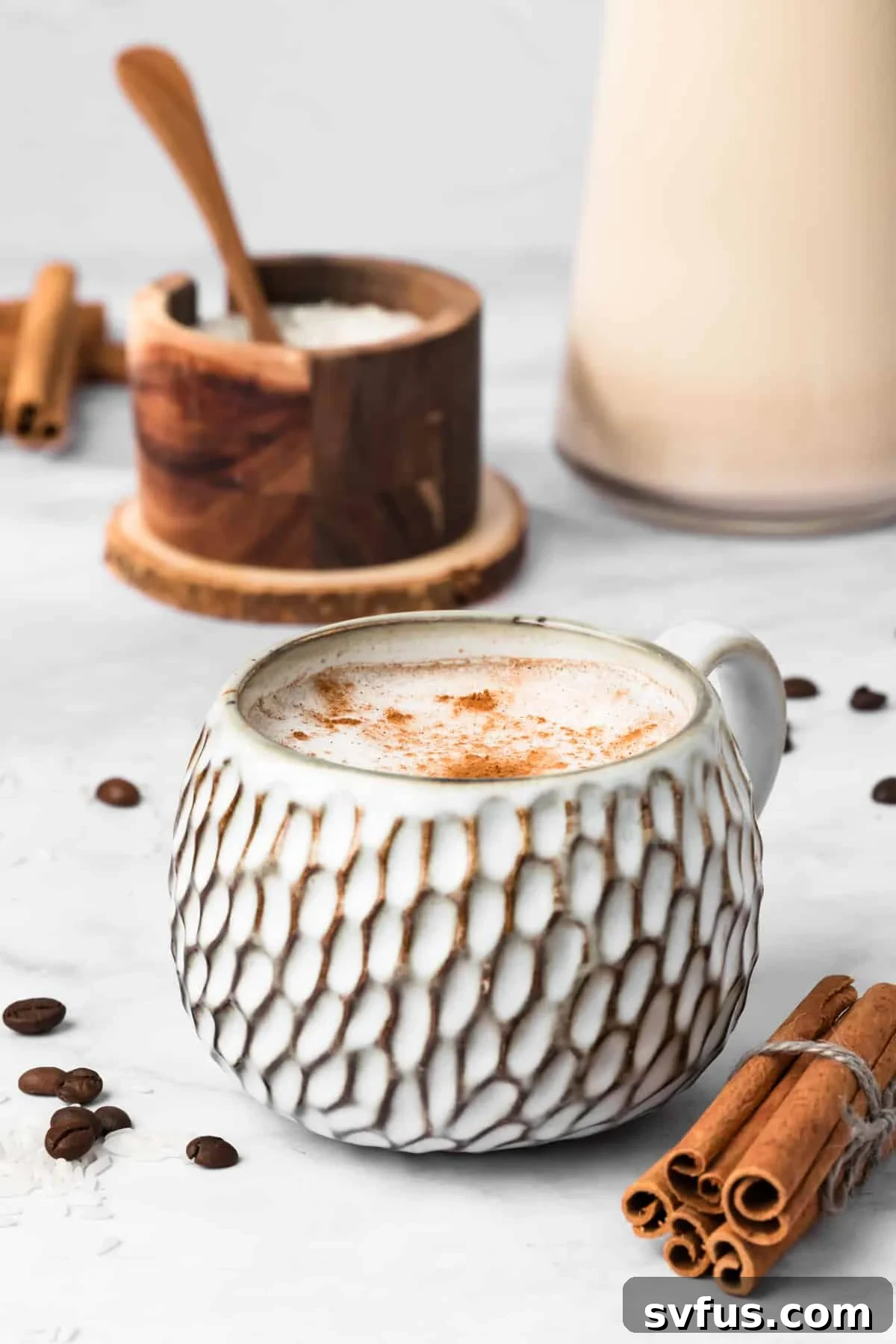 Side view of a cozy hot horchata latte served in a white ceramic mug, garnished with cinnamon.