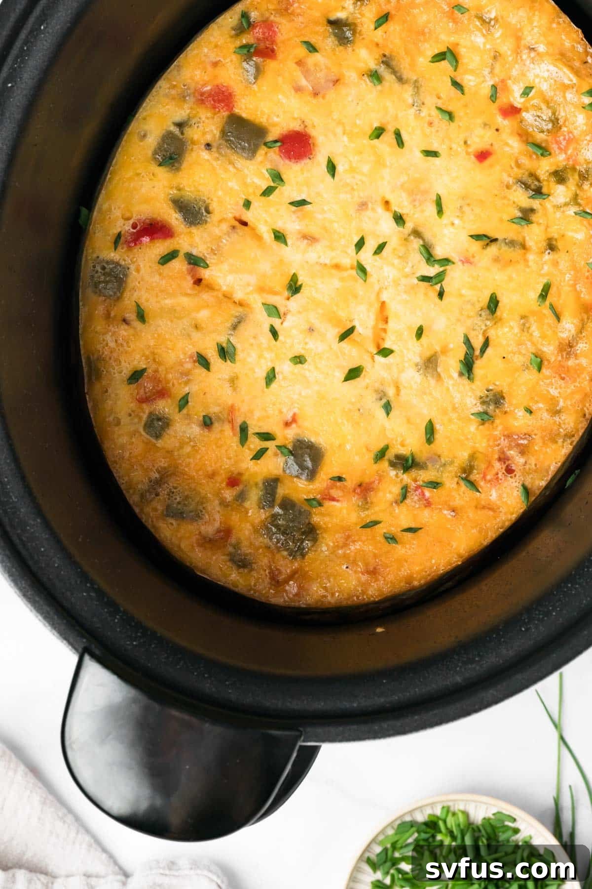 Overhead view of the fully baked and golden-brown breakfast casserole in the crockpot, beautifully cooked and ready to be served.