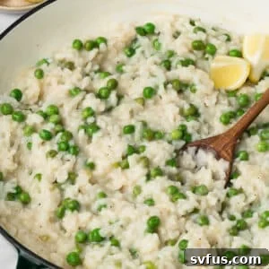 Side view of a wooden spoon in a pot of baked risotto.