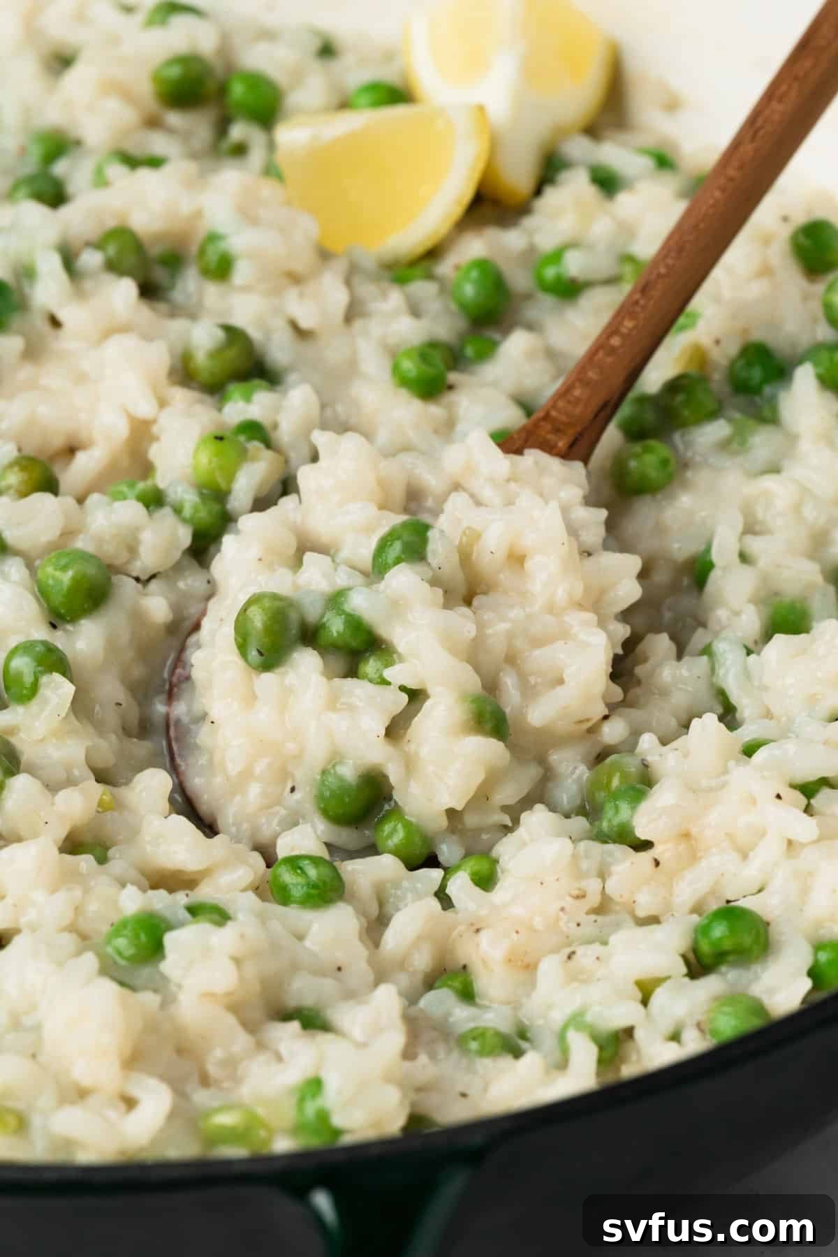 Close-up view of a wooden spoon scooping out a portion of perfectly creamy baked risotto, highlighting its texture.