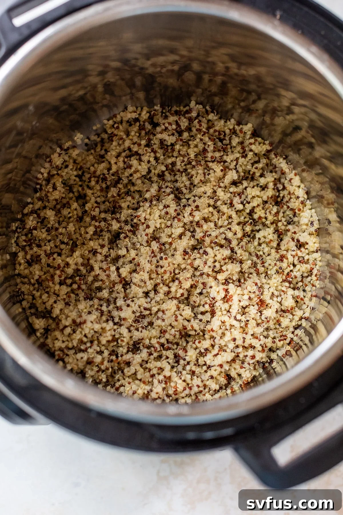 Overhead view of cooked quinoa fluffed and ready for serving in an Instant Pot, illustrating its perfect texture.