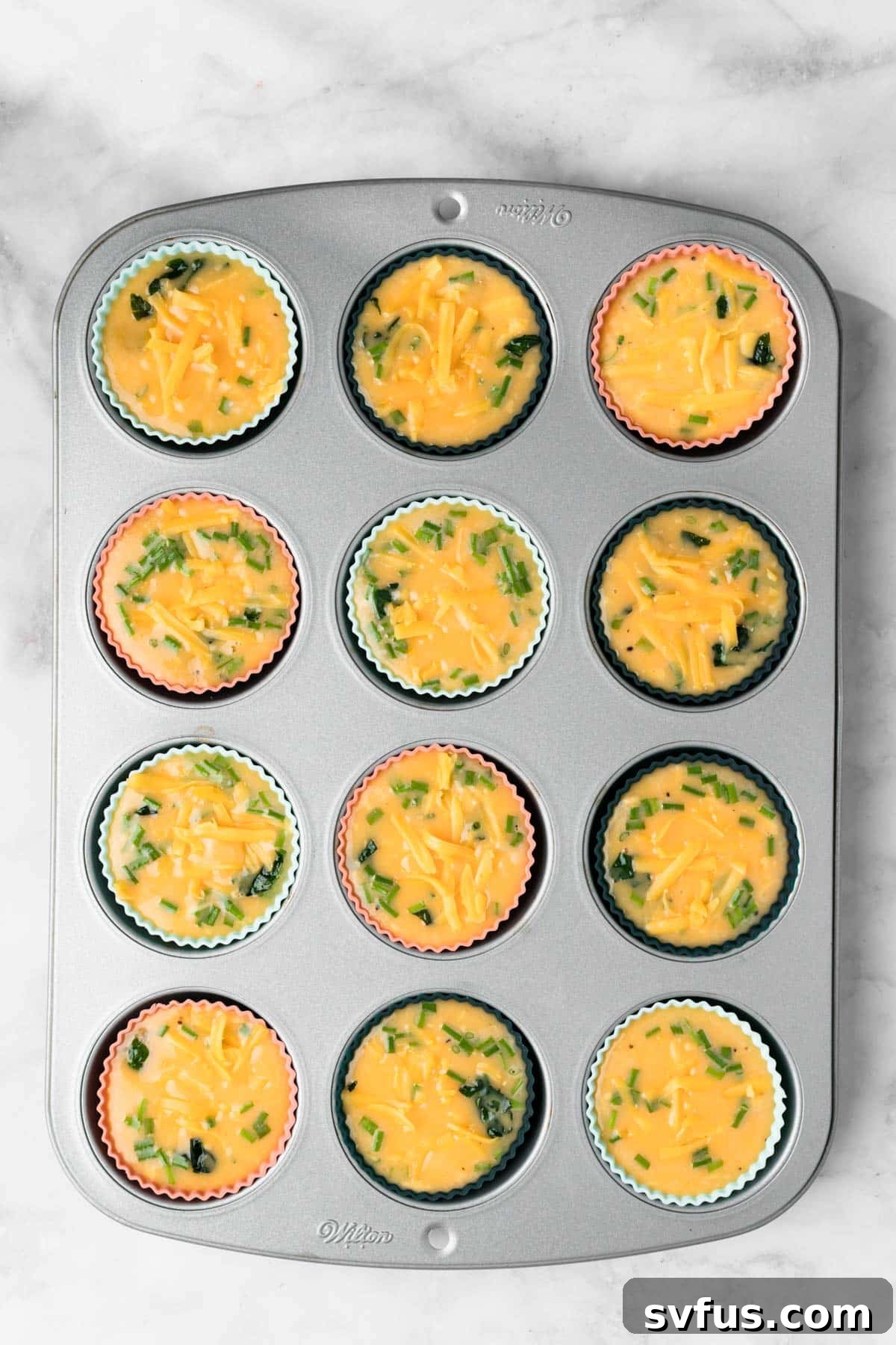 Overhead view of unbaked, high protein egg muffins in a muffin tin.