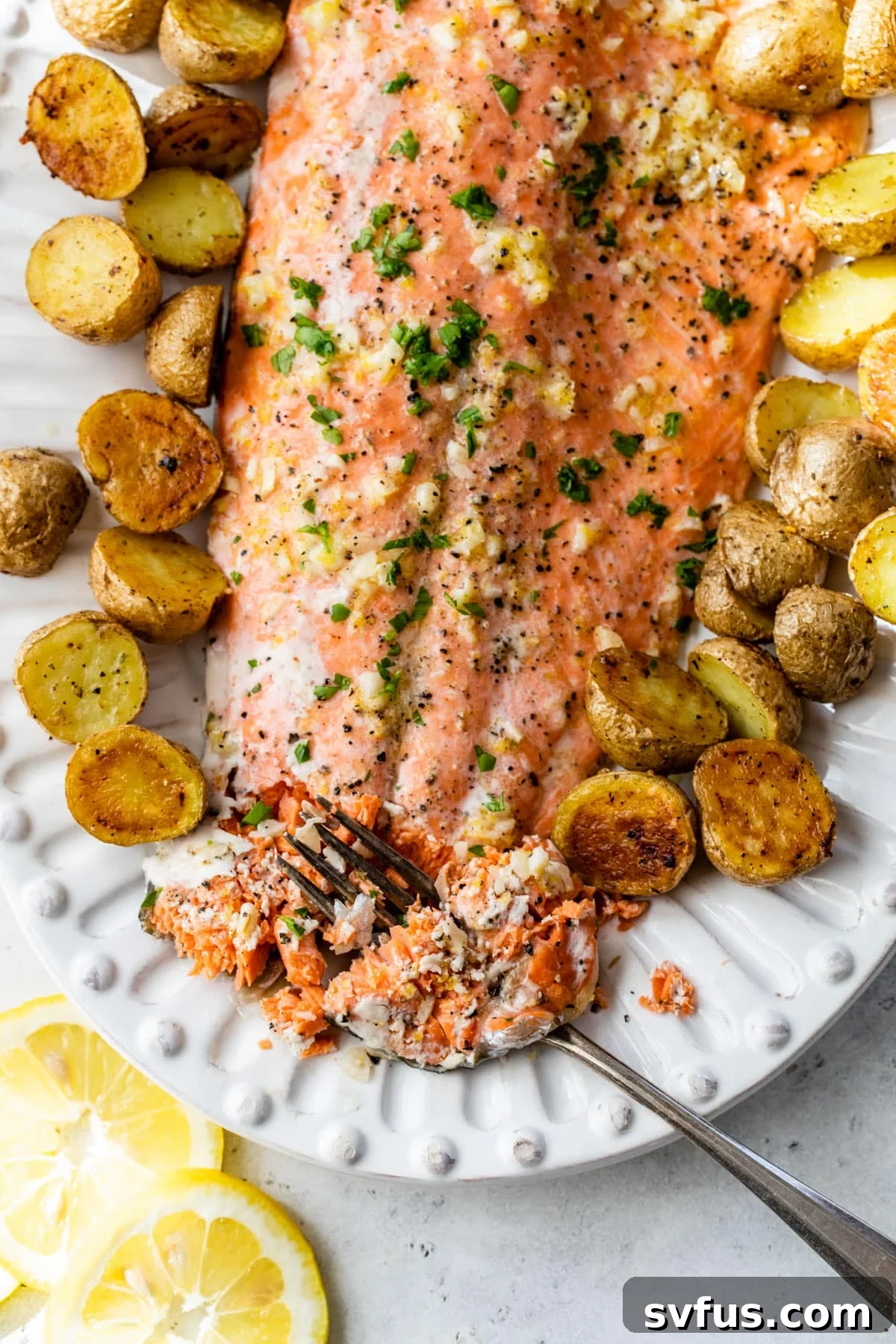 close-up of slow roasted salmon and potatoes on a serving platter with a fork