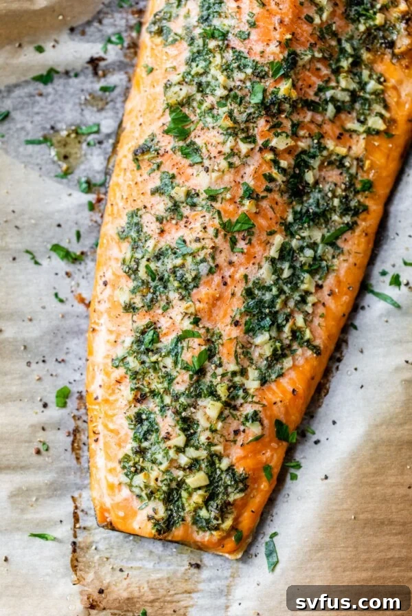 baked salmon fillet with garlic and herbs on parchment paper