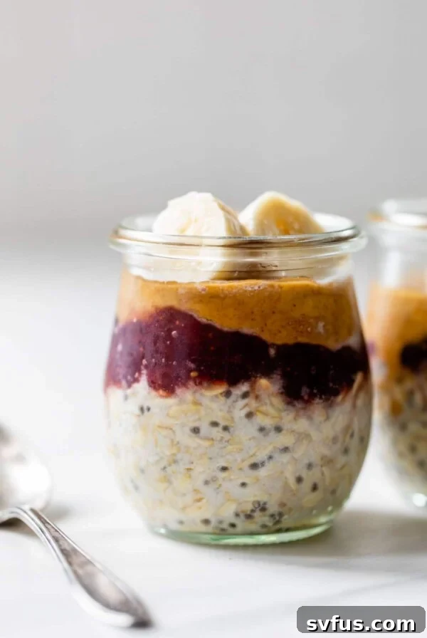 a little jar with oats, peanut butter and jelly and topped with slices of banana