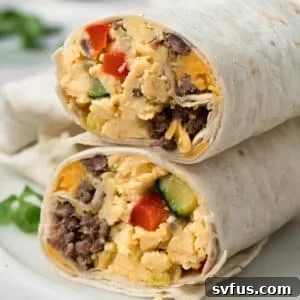 side view of a halved breakfast burrito on a plate.