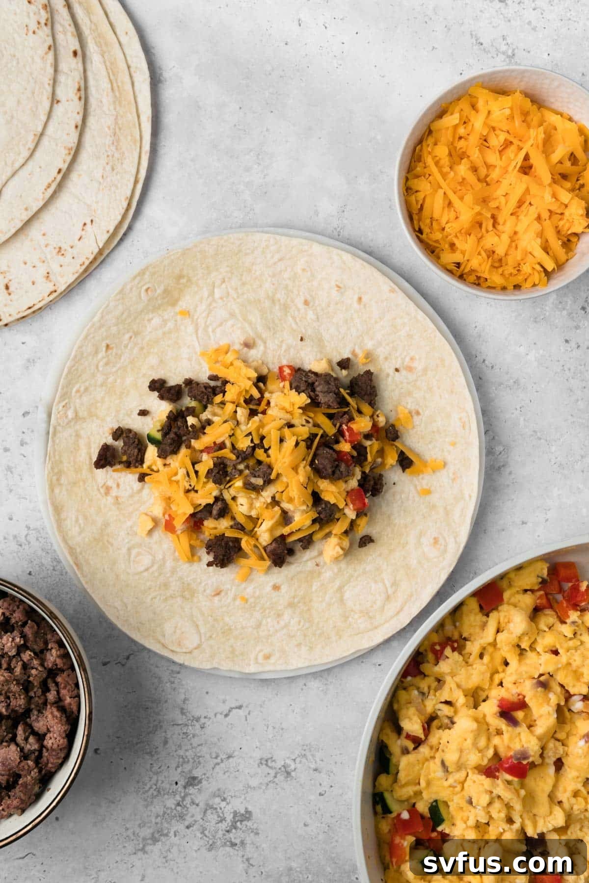 overhead view of a breakfast burrito being assembled.